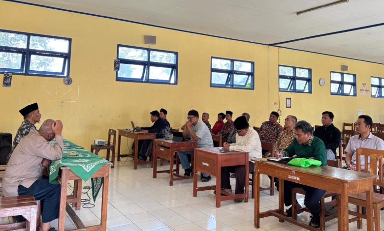 Foto sekelompok pria yang sedang serius mengikuti pelatihan aplikasi SatuMu MASA di dalam sebuah ruang kelas dengan bangku kayu dan dinding kuning. Tampak narasumber di depan kelas sedang mengarahkan peserta yang sedang mengoperasikan laptop.