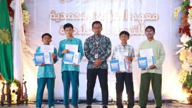 Empat santri berprestasi didampingi seorang asatidz berdiri di atas panggung memegang piagam penghargaan dan voucher dalam acara Khuthbah Ikhtitam pesantren tahfidz dan riset ALMATERA Temanggung.