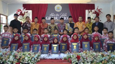 Siswa kelas VI MI Muhammadiyah Purwodadi memegang map kelulusan bersama para guru dan pengurus Majelis Dikdasmen PDM Temanggung di atas panggung graduation ceremony.