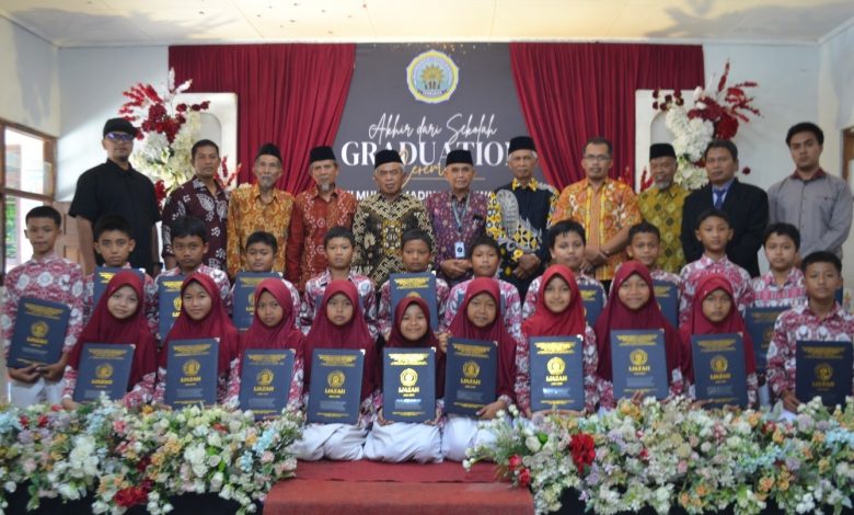 Siswa kelas VI MI Muhammadiyah Purwodadi memegang map kelulusan bersama para guru dan pengurus Majelis Dikdasmen PDM Temanggung di atas panggung graduation ceremony.