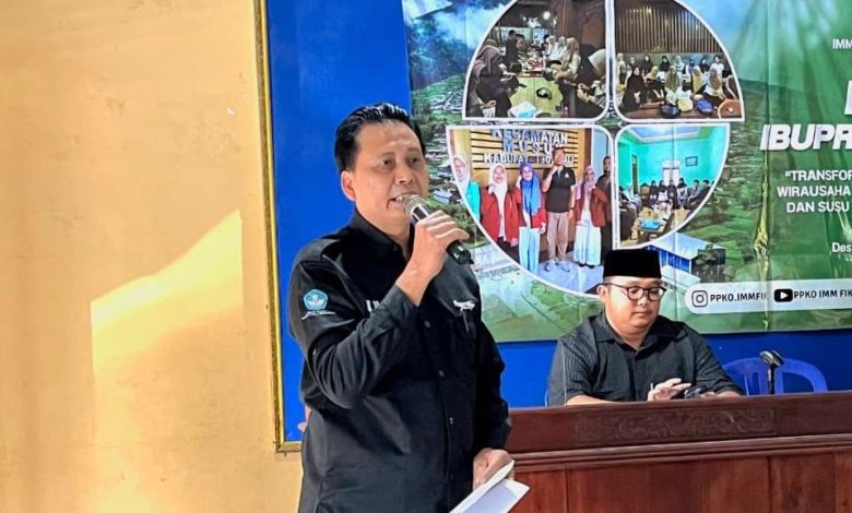Drs. Suyatmin Waskito Adi, M.Si, dari DKPTI UMS, sedang memberikan sambutan pada peluncuran Musuk IbuPreneur Village. Ia memegang mikrofon dan berdiri di depan spanduk acara.