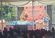 Sebuah pemandangan luas dari dalam tenda besar, memperlihatkan ratusan jemaah yang duduk khusyuk menghadap panggung utama yang dihiasi dekorasi wayang gunungan dan spanduk Tabligh Akbar Milad ke-117 PCM Tersono Batang. Panggung menampilkan pembicara di tengah kerumunan yang tertib.