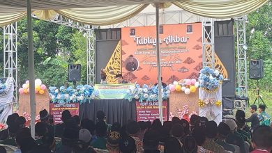 Sebuah pemandangan luas dari dalam tenda besar, memperlihatkan ratusan jemaah yang duduk khusyuk menghadap panggung utama yang dihiasi dekorasi wayang gunungan dan spanduk Tabligh Akbar Milad ke-117 PCM Tersono Batang. Panggung menampilkan pembicara di tengah kerumunan yang tertib.