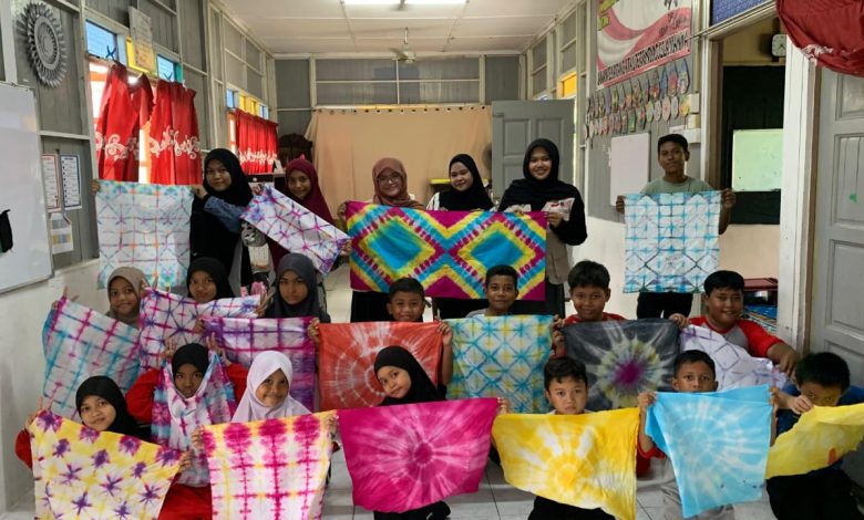 Sebuah grup siswa dari Sanggar Bimbingan (SB) Banting di Selangor, Malaysia, berpose dengan antusias, memamerkan kain batik jumputan berwarna-warni yang mereka buat dalam pelatihan bersama mahasiswa Universitas Muhammadiyah Surakarta (UMS).