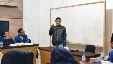 Narasumber sedang memaparkan materi tata kelola organisasi di depan papan tulis saat rapat kerja pimpinan sekolah Muhammadiyah.