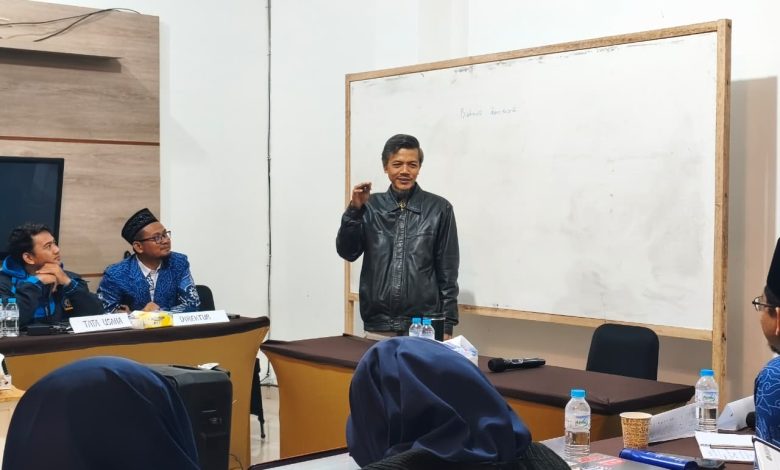 Narasumber sedang memaparkan materi tata kelola organisasi di depan papan tulis saat rapat kerja pimpinan sekolah Muhammadiyah.