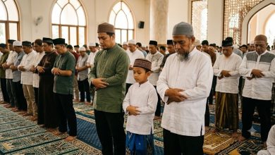 Seorang anak kecil sedang khusyuk shalat berjamaah di saf depan masjid bersama jamaah dewasa, menggambarkan hukum anak kecil di saf depan.