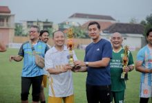 Pemain Doskar UMS FC merayakan kemenangan sebagai juara pertama di podium Wonorejo Cup IV bersama perwakilan pemerintah dan masyarakat.