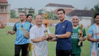 Pemain Doskar UMS FC merayakan kemenangan sebagai juara pertama di podium Wonorejo Cup IV bersama perwakilan pemerintah dan masyarakat.