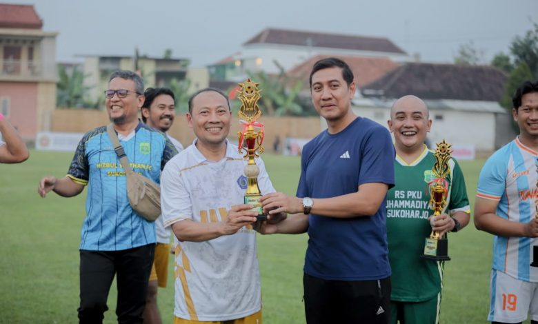 Pemain Doskar UMS FC merayakan kemenangan sebagai juara pertama di podium Wonorejo Cup IV bersama perwakilan pemerintah dan masyarakat.