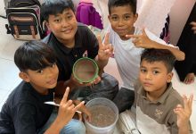 Empat anak laki-laki di Malaysia menunjukkan es krim cokelat hasil eksperimen sains sederhana dalam program KKN Mahasiswa UMS,