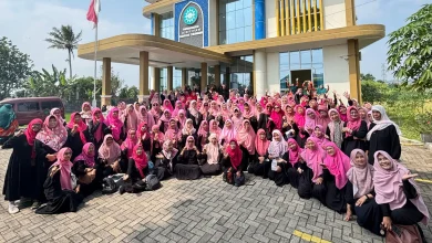 Foto grup besar sekitar seratus wanita anggota 'Aisyiyah mengenakan seragam hitam dan hijab merah muda, tersenyum dan melambaikan tangan di depan Gedung Dakwah 'Aisyiyah Kabupaten Temanggung pada hari yang cerah.