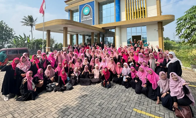 Foto grup besar sekitar seratus wanita anggota 'Aisyiyah mengenakan seragam hitam dan hijab merah muda, tersenyum dan melambaikan tangan di depan Gedung Dakwah 'Aisyiyah Kabupaten Temanggung pada hari yang cerah.
