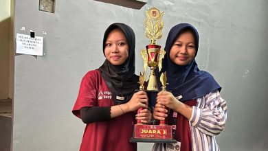 Dua siswi berhijab SMP Muhammadiyah 1 Alternatif Kota Magelang memegang piala juara III Lomba Tari Kreasi Nusantara Piala Bupati Magelang.