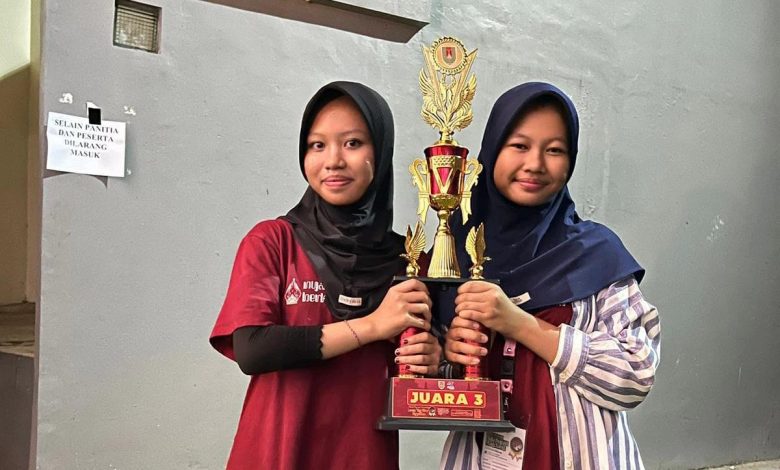 Dua siswi berhijab SMP Muhammadiyah 1 Alternatif Kota Magelang memegang piala juara III Lomba Tari Kreasi Nusantara Piala Bupati Magelang.