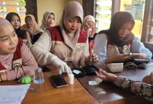 Mahasiswa KKN FIK UMS sedang memakai sarung tangan medis saat melayani warga dalam program cek kesehatan gratis di Desa Waru Sukoharjo.