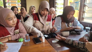 Mahasiswa KKN FIK UMS sedang memakai sarung tangan medis saat melayani warga dalam program cek kesehatan gratis di Desa Waru Sukoharjo.