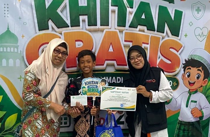 Seorang anak peserta khitan gratis didampingi pendamping dan panitia menunjukkan sertifikat di depan backdrop kegiatan Lazismu dan RS PKU Muhammadiyah Sukoharjo.