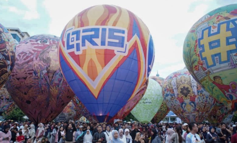 Balon udara raksasa berlogo QRIS milik Bank Indonesia Purwokerto terbang di tengah festival untuk kampanye edukasi transaksi keuangan digital.
