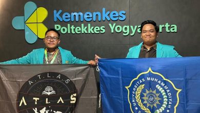 Dua mahasiswa Universitas Muhammadiyah Surakarta membentangkan bendera almamater dan bendera ATLAS setelah meraih penghargaan riset ilmiah.