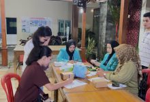 Mahasiswa KKN FIK UMS berjaket almamater toska sedang melayani pendaftaran dan pencatatan digital kesehatan remaja di Desa Siwal Sukoharjo.