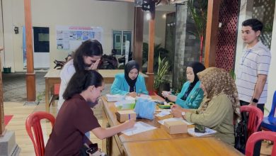 Mahasiswa KKN FIK UMS berjaket almamater toska sedang melayani pendaftaran dan pencatatan digital kesehatan remaja di Desa Siwal Sukoharjo.