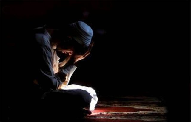 Seorang pria Muslim bersujud dan menangis dalam doa di ruangan gelap beralaskan sajadah sebagai simbol refleksi diri dan taubat