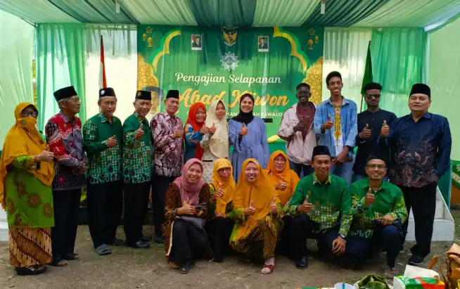 Mahasiswa Internasional UMP asal Palestina, Sudan, dan Mali berpose mengacungkan jempol bersama pengurus dan jamaah di depan panggung Pengajian Selapanan Ahad Kliwon PCM Rawalo.