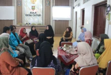 Sekelompok mahasiswa berjas almamater biru muda dan warga Desa Catur, Boyolali, mengikuti sesi diskusi kelompok melingkar dalam kegiatan pelatihan Pojok Harmoni tentang solusi kesehatan mental ibu di Aula Desa Catur.