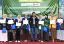 Tim Mahasiswa TMU juara MCEBI 2026 berfoto di panggung bersama panitia MCEBI PTMA 2026.