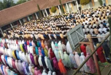 Ratusan siswa-siswi sekolah berkumpul dan berbaris rapi di lapangan untuk melakukan sholat dhuha berjamaah di masjid sekolah, terlihat siswa laki-laki di depan dengan seragam pramuka dan siswa perempuan di belakang dengan mukena warna-warni.