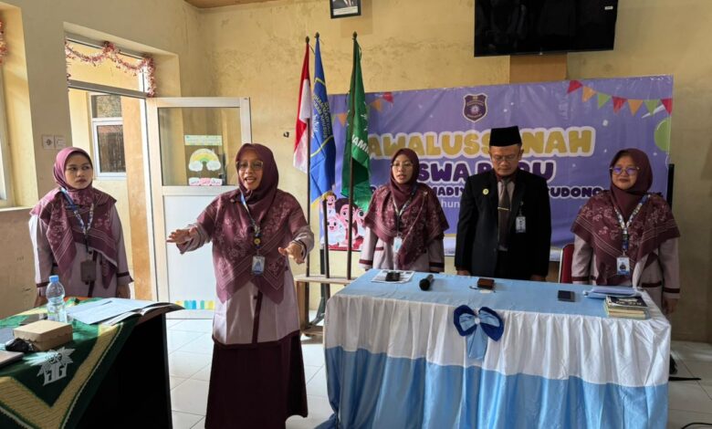 Empat orang pengurus sekolah atau guru sedang berdiri di depan peserta dalam acara formal sekolah, dengan latar belakang spanduk bertuliskan "SD Muhammadiyah".