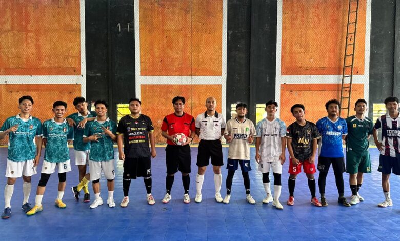 Para peserta pertandingan futsal dalam gelaran Festival Mahasiswa FAI UMP berfoto bersama dengan wasit di lapangan.