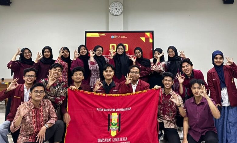 Foto bersama kader PK IMM Kedokteran UMP setelah kegiatan Darul Arqam Dasar, memegang bendera IMM dan melakukan pose tangan IMM.