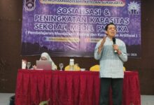 Ketua Majelis Pendidikan PDM Surakarta memberikan sambutan dalam sosialisasi transformasi SMP Muhammadiyah 4 menjadi SMP Muhammadiyah Boarding School Solo di sebuah aula hotel.