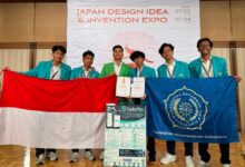 Mahasiswa UMS membawa bendera Indonesia dan menunjukkan sertifikat prestasi SafeTKI pelindung Pekerja Migran Indonesia di ajang JDIE 2026 Jepang.