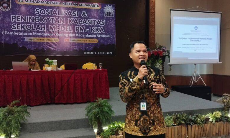 Seorang pria berbaju batik memberikan presentasi mengenai Kebijakan Implementasi Sekolah Model PM dan KKA di SD Muhammadiyah 1 Solo.