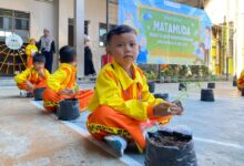 Murid baru memegang bibit sayuran saat mengikuti Masa Pengenalan Lingkungan Sekolah di MIM Digdaya Bolon.