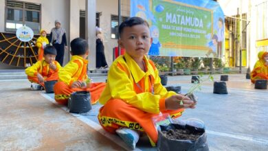 Murid baru memegang bibit sayuran saat mengikuti Masa Pengenalan Lingkungan Sekolah di MIM Digdaya Bolon.