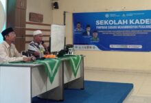 Dua pria duduk di depan proyektor yang menampilkan slide "terimakasih" pada acara Sekolah Kader Muhammadiyah Pekajangan di Pekalongan.
