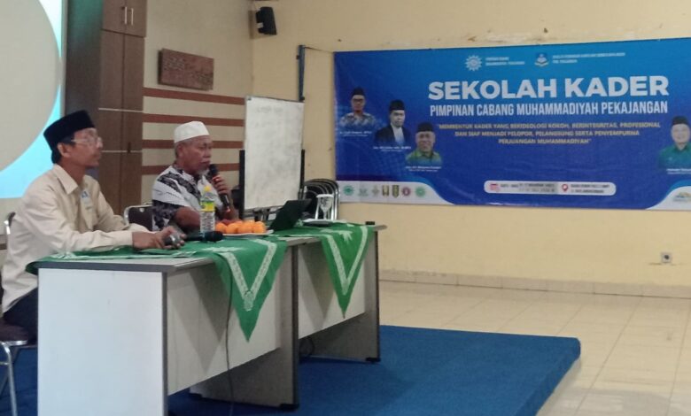 Dua pria duduk di depan proyektor yang menampilkan slide "terimakasih" pada acara Sekolah Kader Muhammadiyah Pekajangan di Pekalongan.