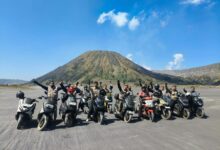 Rombongan anggota komunitas BikersMu Sragen berpose dengan sepeda motor matic di padang pasir Gunung Bromo dengan latar belakang bukit Teletubbies.