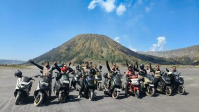 Rombongan anggota komunitas BikersMu Sragen berpose dengan sepeda motor matic di padang pasir Gunung Bromo dengan latar belakang bukit Teletubbies.