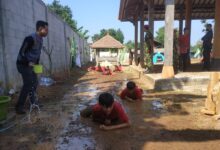 Peserta Diklatsar Kokam merayap di lumpur dalam latihan fisik di bawah pengawasan instruktur.
