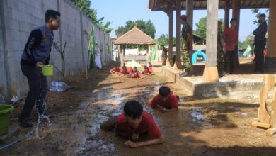 Peserta Diklatsar Kokam merayap di lumpur dalam latihan fisik di bawah pengawasan instruktur.