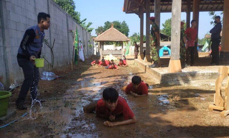 Peserta Diklatsar Kokam merayap di lumpur dalam latihan fisik di bawah pengawasan instruktur.