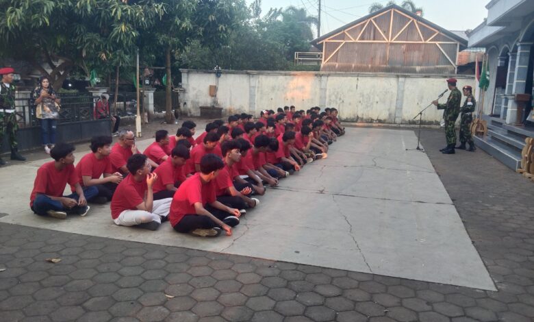Seorang instruktur senior berbaju merah sedang memberikan arahan langsung kepada peserta Diklatsar Kokam 2026.