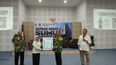 Bunga hortensia biru yang mekar dengan kelopak padat di tengah dedaunan hijau.