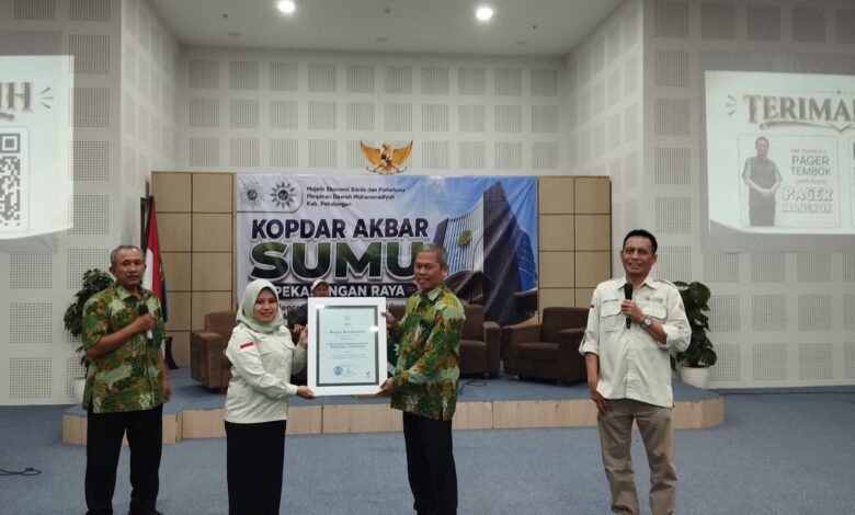 Bunga hortensia biru yang mekar dengan kelopak padat di tengah dedaunan hijau.
