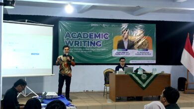 Narasumber sedang memberikan materi dalam workshop Academic Writing UMBS di depan spanduk bertuliskan "ACADEMIC WRITING: Strategi Menulis Artikel Ilmiah Berkualitas menuju Jurnal Bereputasi".